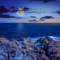 Sea Ã¢â¬â¹Ã¢â¬â¹wave breaks about boulders at night Royalty Free Stock Photo